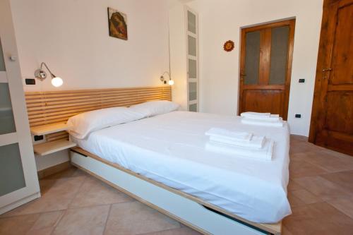 ノチェーラ・テリネーゼにあるB&B dei Vicoliのベッドルーム(白い大型ベッド1台、木製ヘッドボード付)