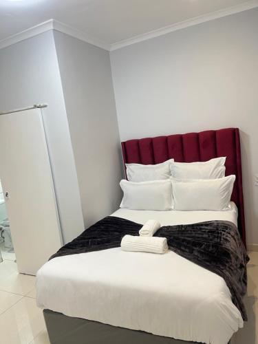 a bedroom with a large bed with a red headboard at The Perfect Place in Parow