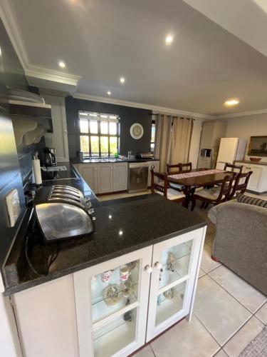 a kitchen with a sink and a counter top at Stoneridge Large Family Cottage in Plettenberg Bay