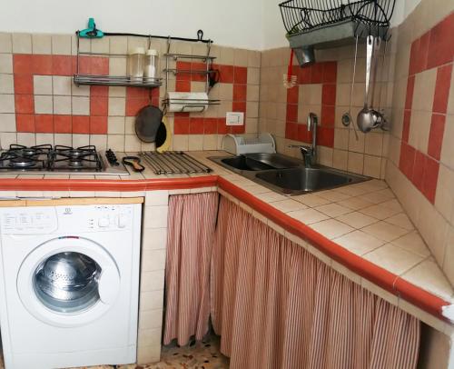 eine Küche mit einer Waschmaschine und einem Waschbecken in der Unterkunft La Casetta Al Mare in Santa Marinella