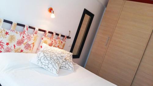 ein Schlafzimmer mit einem weißen Bett mit Kissen und einem Schrank in der Unterkunft La Casetta Al Mare in Santa Marinella