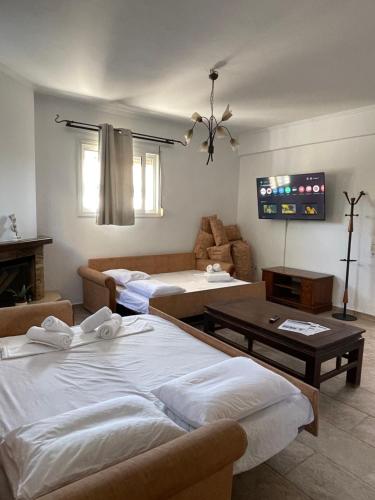 a living room with two beds and a couch at Oikos Corfu in Alepou