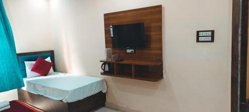 a room with a bed and a tv on a wall at Hotel AL Taj , Agra in Agra