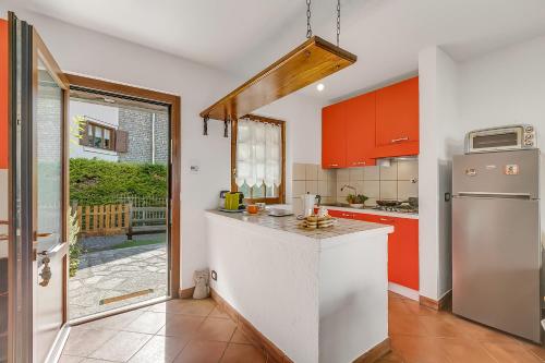 cocina con armarios rojos y nevera blanca en La Casa Di Dadà - Happy Rentals, en Oulx