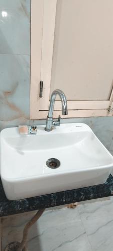 a white sink in a bathroom with a mirror at Hotel AL Taj , Agra in Agra