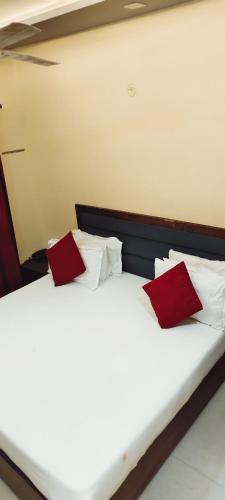 a bedroom with two beds with red and white pillows at Hotel AL Taj , Agra in Agra