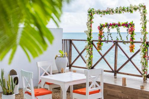 Una mesa y sillas en una terraza con vista al mar. en ZAN Sun Beach, en Makunduchi