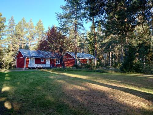 eine rote Scheune mitten auf einer Wiese in der Unterkunft Jävregården in Jävre
