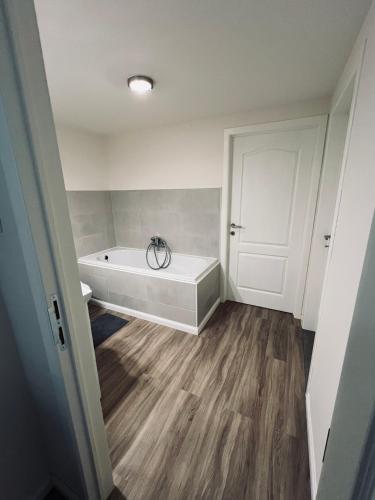 a bathroom with a bath tub in a room at Ruime suite met privé ingang en badkamer in Genk