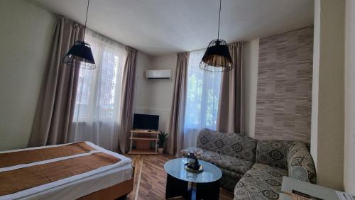 a living room with a bed and a couch at The English Guest House in Ruse