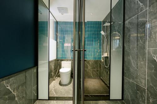 a bathroom with a toilet and a glass shower at HN Apartment and Hotel in Tài Xá