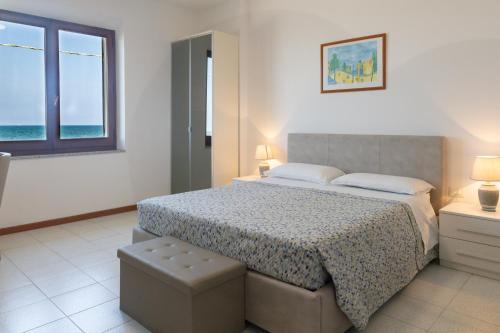 a bedroom with a bed with a view of the ocean at Villa Fausta in La Maddalena