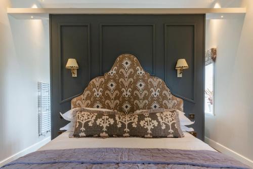 a bedroom with a large bed with a black headboard at The 3 Acres Inn & Restaurant in Huddersfield