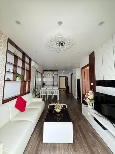 a living room with a white couch and a table at Chuỗi Homestay Bãi Cháy Hạ Long in Ha Long