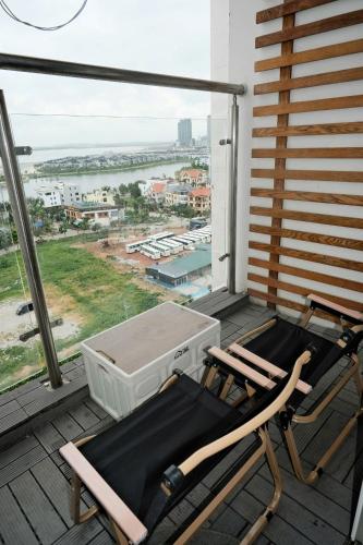 a balcony with two chairs and a large window at Chuỗi Homestay Bãi Cháy Hạ Long in Ha Long