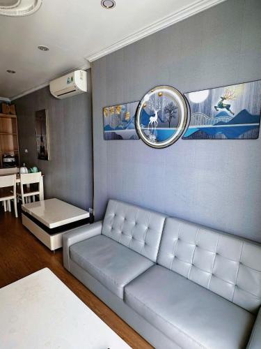 a living room with a couch and a clock on the wall at Chuỗi Homestay Bãi Cháy Hạ Long in Ha Long