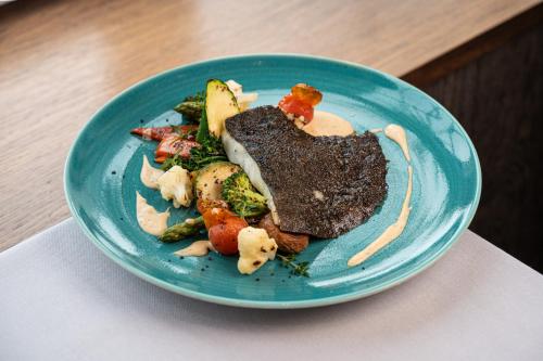 a blue plate of food with meat and vegetables at Catalonia Reina Victoria in Ronda