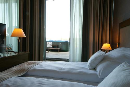 a bed in a hotel room with a large window at Apartamenty IRS Havet in Dźwirzyno