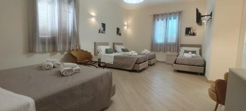a hotel room with two beds and a couch at B&B Villa Colomba in Agrigento