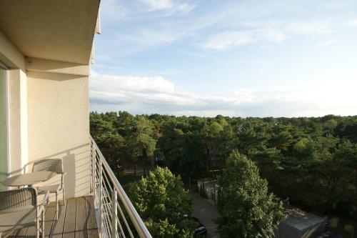 a balcony of a building with a view of trees at Apartamenty IRS Havet in Dźwirzyno