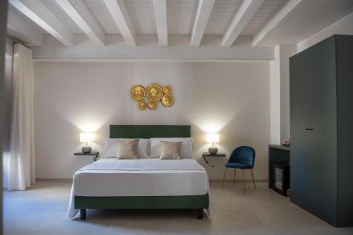 a bedroom with a bed and a blue chair at Luxury B&B Maison Madre in the historic center of Avola in Avola