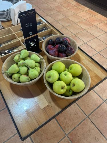 three bowls of fruit sitting on top of a counter at Doña Lola in Castellón de la Plana