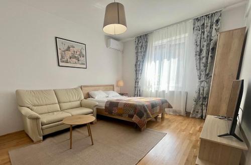 a small living room with a couch and a bed at Bucharest Airport Stay & Fly in Otopeni