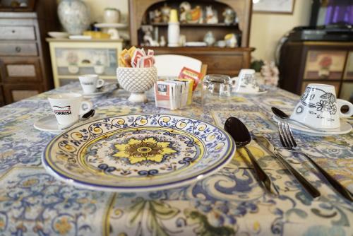 a table with a blue and white plate and utensils at B&B Villa Colomba in Agrigento