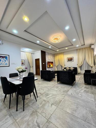a large living room with a table and chairs at Elk's Place in Enugu