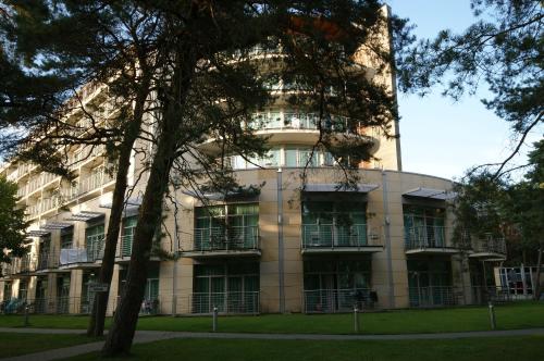 a building with a tree in front of it at Apartamenty IRS Havet in Dźwirzyno