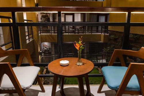 a table with a vase of flowers on a balcony at Grand Sunshine Resort & Convention in Bandung