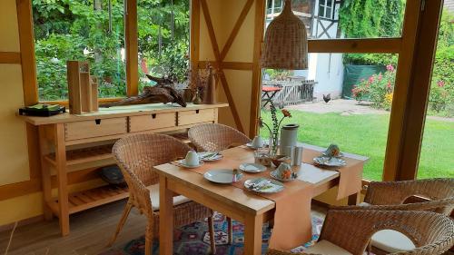 a dining room with a table and chairs and a window at Hotel garni & Oma's Heuhotel 'Pension zur Galerie' in Barby