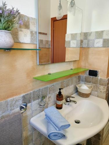 a bathroom sink with a mirror and a towel at Heleni Apartment in Tortoreto Lido