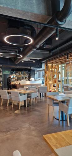 a restaurant with tables and chairs in a room at Apartamenty IRS Havet in Dźwirzyno