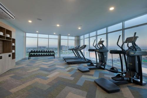 a gym with cardio equipment in a room with windows at Residence Inn by Marriott Merida in Mérida
