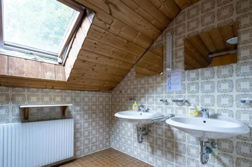 a bathroom with two sinks and a window at Gästehaus in Finnentrop