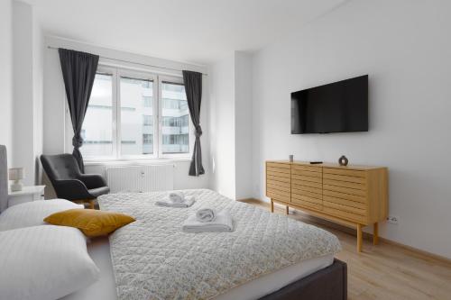 a bedroom with a bed and a tv and a chair at Apartment with 2 bedrooms with kitchen near metro in Prague