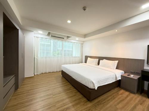 a bedroom with a large bed and a window at Civic Park in Bangkok