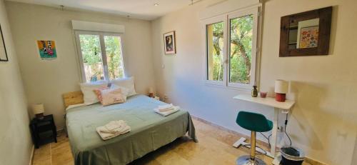 une chambre avec un lit et une chaise dedans dans l'établissement La Maison du Soleil, à Saint-Didier