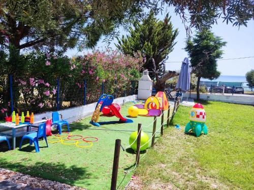a park with a playground with a table and play equipment at Dream house by the sea in Mola Kalyva