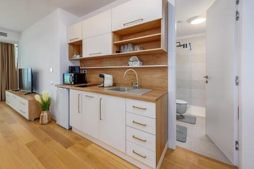 a kitchen with white cabinets and a sink at Relax Blue VOGH in Olimp