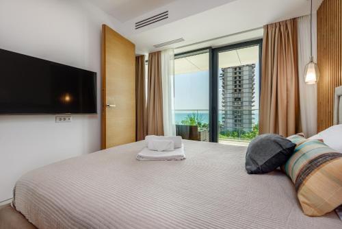 a bedroom with a large bed with a large window at Relax Blue VOGH in Olimp