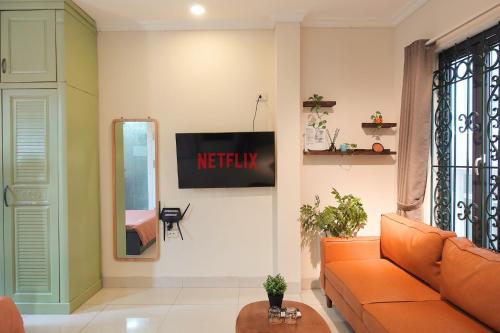 a living room with a couch and a tv on the wall at Migo Housing - Lift Access - Hanoi Beer Street - Central and Spacious - Ensuite Kitchen - Ensuite Bathroom in Hanoi
