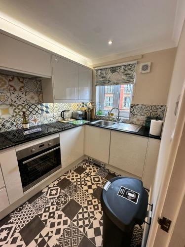 a kitchen with a trashcan in the middle of a kitchen at Marina Flat, Swansea - Perfect Location in Swansea