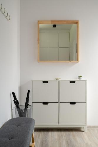 a white dresser with a mirror on a wall at Apartmány v Rezidenci Podhradí in Štramberk