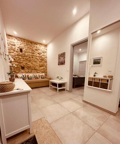 a large living room with a couch and a stone wall at Tannur Del Carmine in Noto
