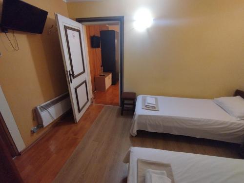 a small room with two beds and a mirror at The English Guest House in Ruse