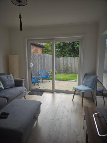 a living room with a couch and a sliding glass door at 2 bed room house available with free parking in Belfast