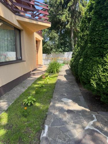 a stone walkway next to a house with a fence at Pensiunea Crescent Predeal in Predeal