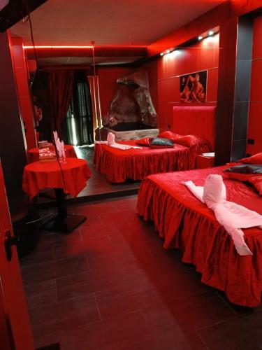 a red room with two beds and a mirror at Hotel La Fayette Giugliano Licola in Giugliano in Campania